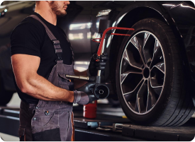 Tyre technician fitting a wheel in a workshop